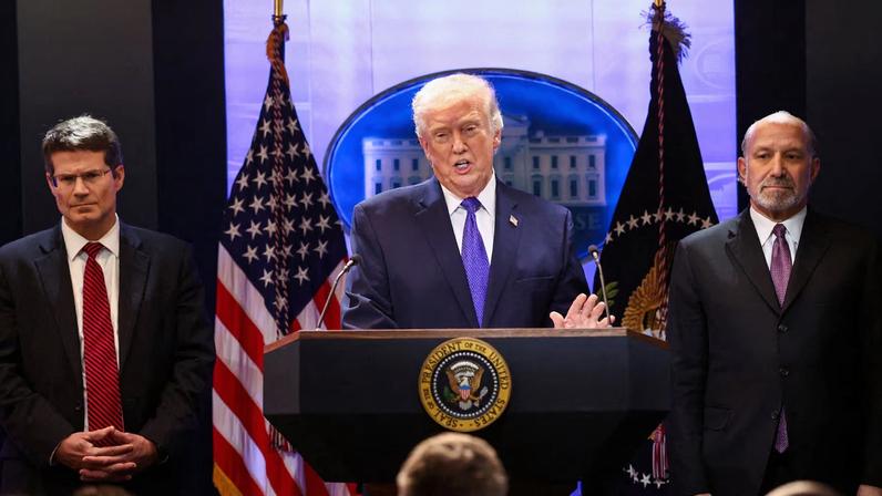 U.S. President Donald Trump, flanked by Secretary of Commerce Howard Lutnick and Solicitor General D. John Sauer, speaks during a press briefing at the White House, following the Supreme Court's ruling that Trump had exceeded his authority when he imposed tariffs, in Washington, D.C., U.S., February 20, 2026. REUTERS/Kevin Lamarque