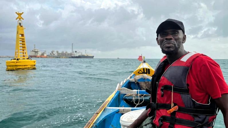 A small-scale fisherman in front of a buoy marking the boundary of his fishing zone. Image by Elodie Toto/Mongabay.