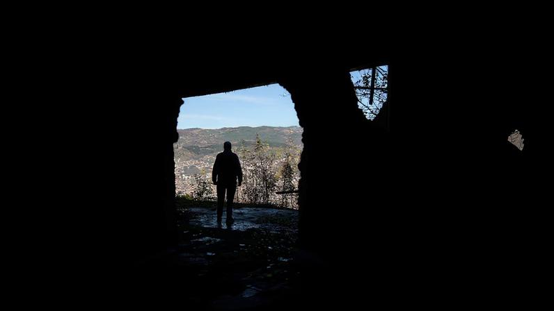 A Bosnian worker looks out at Sarajevo through a hole in a war-damaged building that once marked the front line during the 1992–95 Bosnian War, in Sarajevo, Bosnia and Herzegovina, November 13, 2025. REUTERS/Amel Emric/File Photo