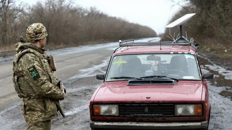 Un soldado ucranio observa una antena de Starlink colocada sobre un coche en el frente de Donetsk en febrero de 2023