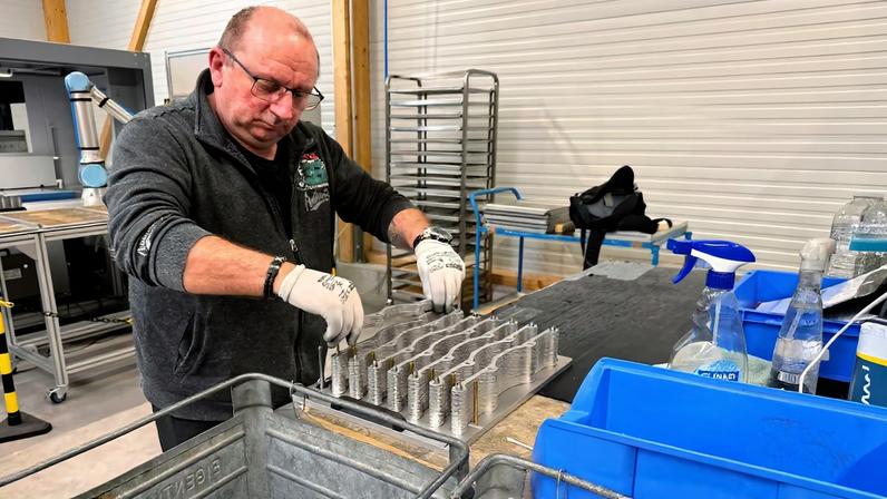 A worker operates machinery at the production facility of Dostech GmbH in Moessingen