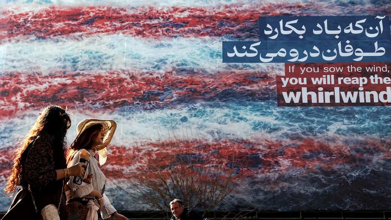 Iranian women walk past an anti-U.S. billboard in Tehran, Iran, February 19, 2026. Majid Asgaripour/WANA (West Asia News Agency) via REUTERS