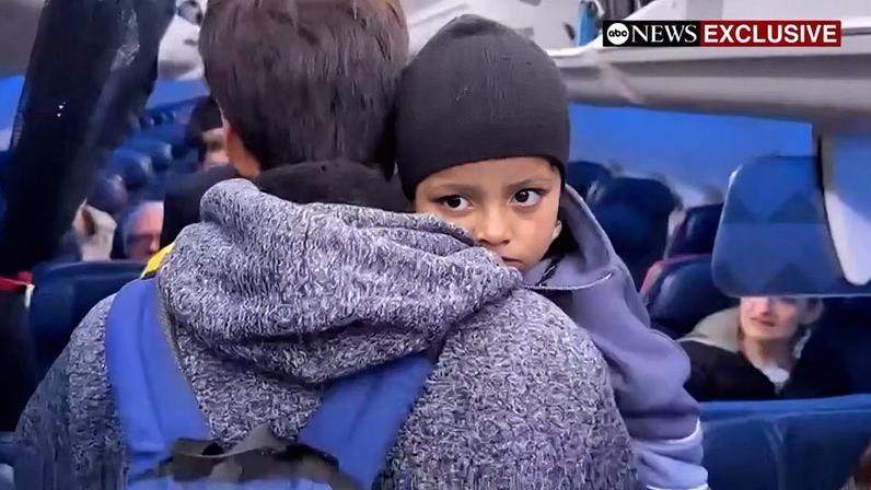 Liam Conejo Ramos is held by his father Adrian Alexander Conejo Arias while boarding an aircraft to return to Minneapolis