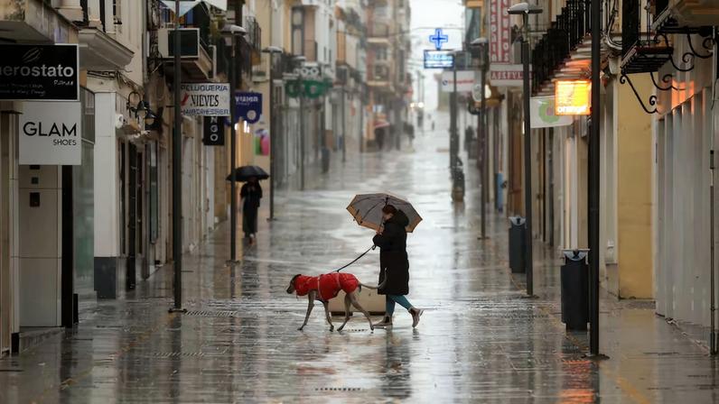 People walk in a shopping area amid rain as storm Leonardo hits parts of Spain, in Ronda, Spain, February 4, 2026. REUTERS/Jon Nazca