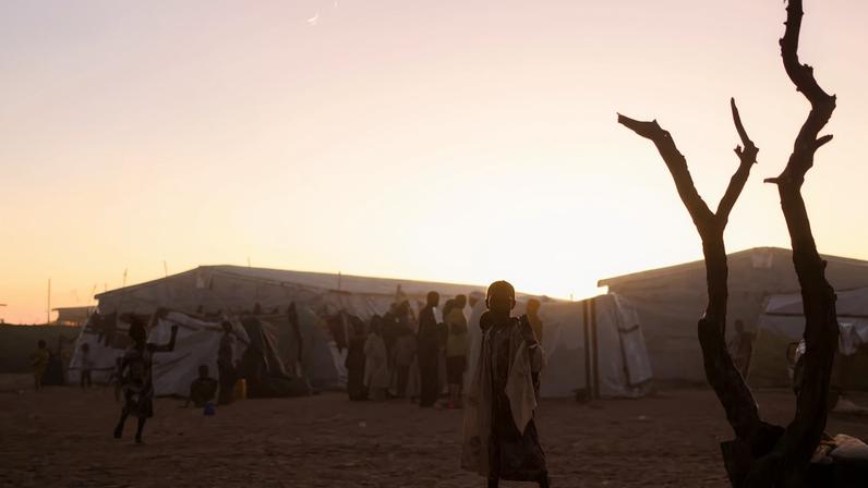 Sudanese refugees from al-Fashir gather at sunset in the Tine transit camp amid the conflict between the paramilitary Rapid Support Forces (RSF) and the Sudanese Army, in eastern Chad, November 23, 2025.