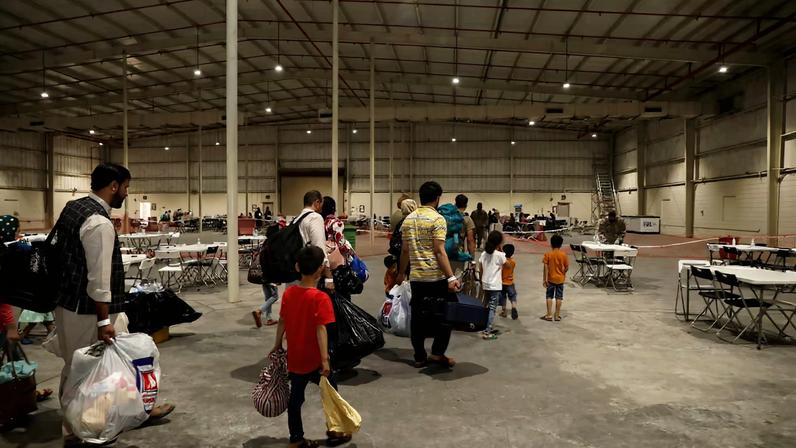 Special Immigrants from Afghanistan walk through the in-processing building after their evacuation at Camp As Sayliyah, Qatar, August 20, 2021. Picture taken August 20, 2021. U.S. Army/Sgt. Jimmie Baker/Handout via REUTERS