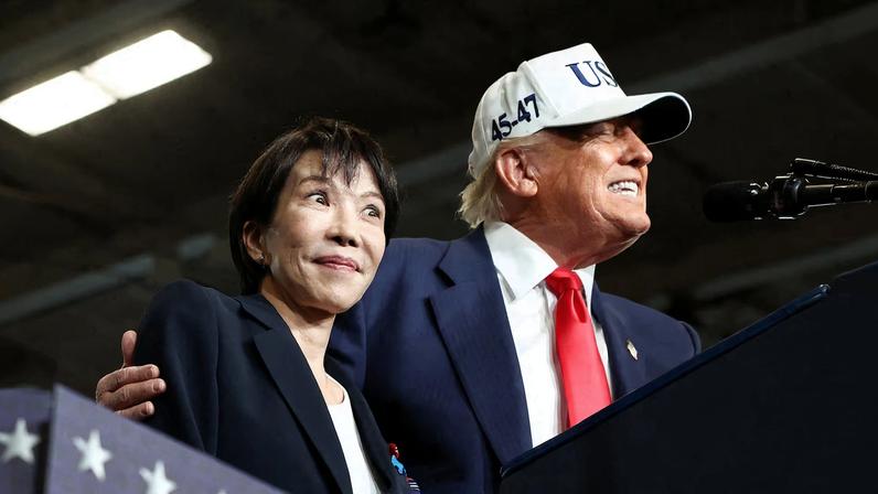 Japanese Prime Minister Sanae Takaichi reacts as U.S. President Donald Trump speaks, aboard the aircraft carrier USS George Washington, during a visit to U.S. Navy's Yokosuka base in Yokosuka, Japan