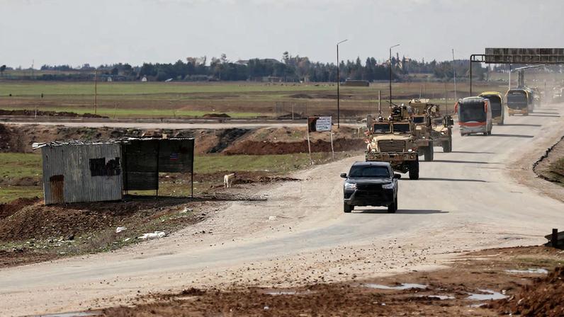 U.S. military vehicles move ahead of buses transporting Islamic State detainees from Syria to Iraq, according to a security source from the Syrian Democratic Forces, in Qamishli, Syria, February 8, 2026.