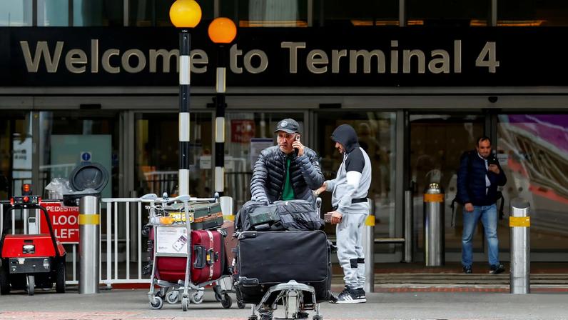 A traveller walks outside the Terminal 4 at Heathrow International Airport near London, Britain, March 21, 2025. REUTERS/Carlos Jasso/File Photo