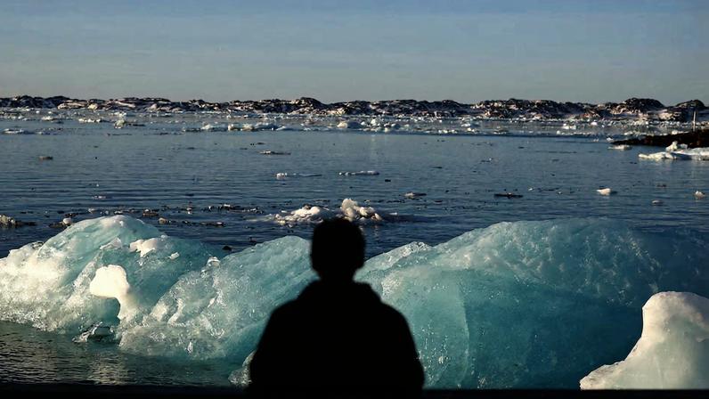 A man looks at floating ice at the old harbour of Nuuk, Greenland, January 29, 2026. REUTERS/Stoyan Nenov