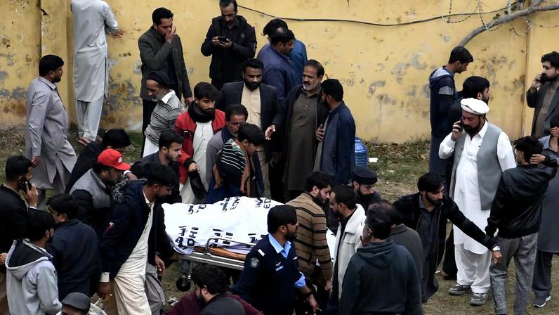 Varios hombres trasladan el cadáver de una de las víctimas mortales de la explosión en una mezquita de la capital de Pakistán, Islamabad, este viernes.