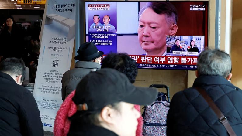People watch a news report on the sentencing trial of South Korean former president Yoon Suk Yeol's insurrection case in Seoul