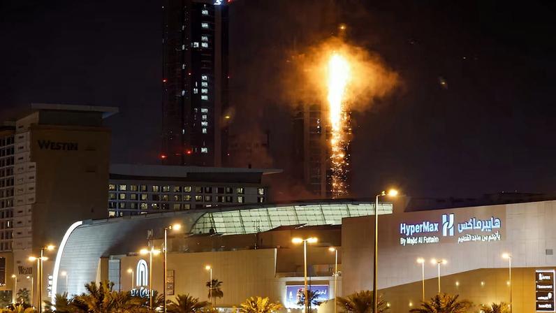 Smoke rises from a burning building hit by an Iranian drone strike in Manama