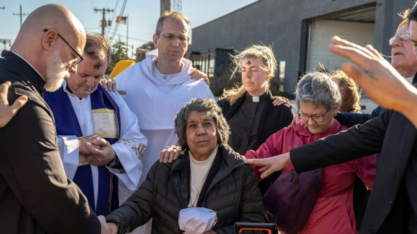 Faithful pray over two priests and a nun before they deliver communion and ashes to people detained in an immigration detention facility, in Broadview