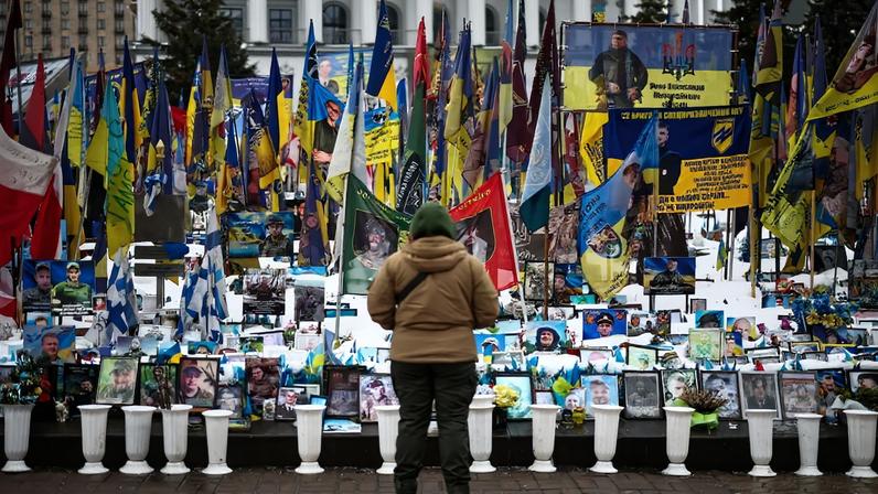 A person stands at a makeshift memorial to fallen Ukrainian and foreign soldiers in Kyiv.