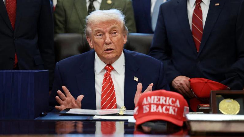 U.S. President Donald Trump sits at his desk, behind a hat that reads "America is back" at the White House in Washington, D.C., U.S., February 3, 2026. REUTERS/Evelyn Hockstein/File Photo