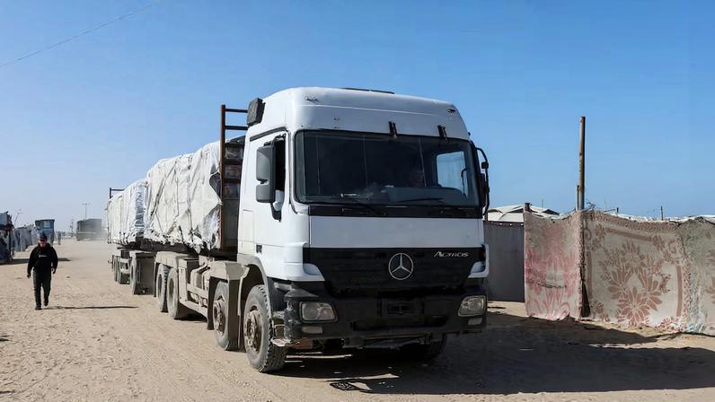 Aid trucks move on a road after entering Gaza through the Kerem Shalom crossing, in Rafah
