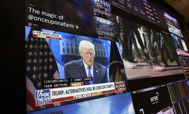 A press conference on tariffs by U.S. President Donald Trump is displayed on a television as traders work on the floor of the New York Stock Exchange during afternoon trading in New York City on Feb. 20.