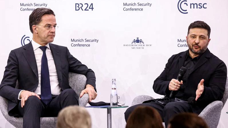 NATO Secretary General Mark Rutte sits next to Ukrainian President Volodymyr Zelenskiy as he speaks during the Munich Security Conference (MSC) in Munich, Germany, February 14, 2026.