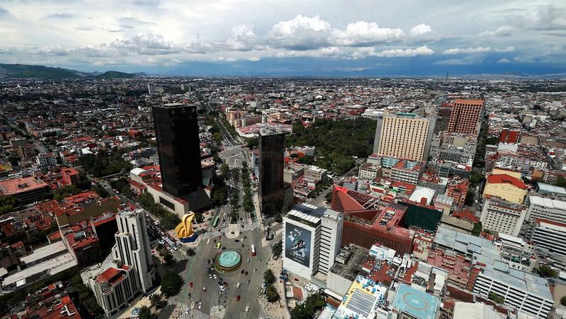 A general view of buildings and houses in Mexico City, Mexico July 1, 2025. Photograph taken through a glass window of a building.