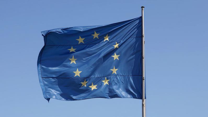 The European Union (EU) flag is seen on a sunny day and blue sky at the Chancellery in Berlin