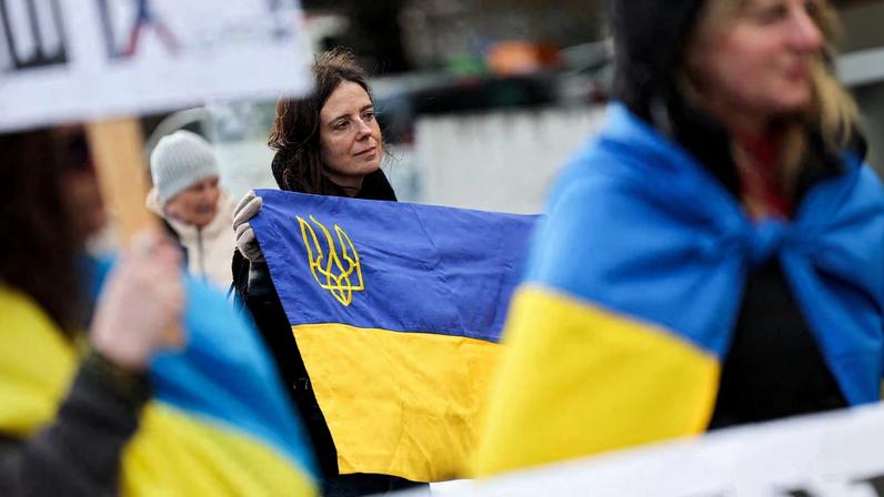 A woman holds a Ukrainian flag at a protest near the United Nations office, on the day of U.S.-mediated peace talks between Russia and Ukraine in Geneva, Switzerland, February 17, 2026.