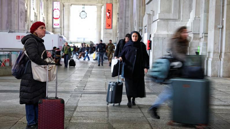 A woman looks at a board announcing delays at the Milan train station, as Italian police investigate possible sabotage to electricity cables near the city of Bologna that have caused delays to a large part of the national railway network, in Milan, Italy, February 7, 2026.
