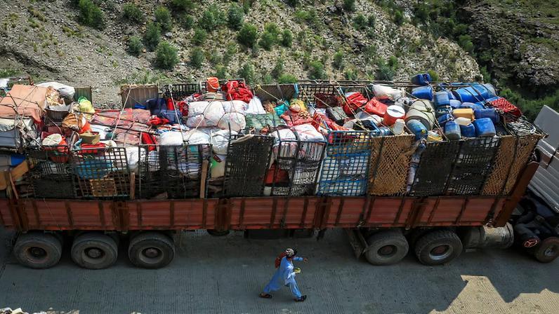 A man walks past a truck loaded with belongings of Afghan nationals, as they head back to Afghanistan after Pakistan started to deport documented Afghan refugees, near Torkham border crossing between Pakistan and Afghanistan, September 1, 2025.