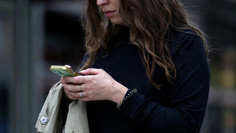 A woman uses a smartphone in London, Britain, October 6, 2024. REUTERS/Hollie Adams