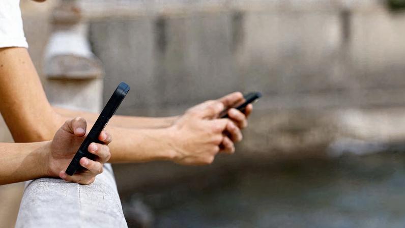 People use social media on their mobile phones in Arinaga, on the island of Gran Canaria, Spain, February 3, 2026. REUTERS/Borja Suarez/File Photo