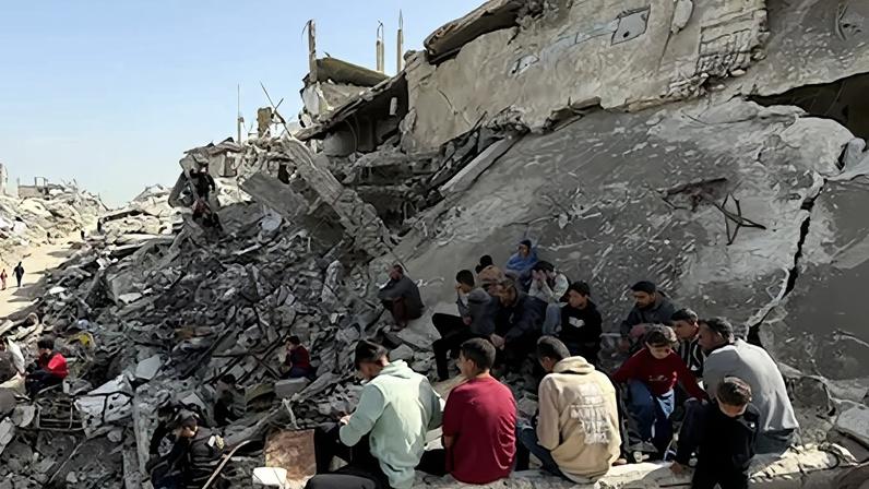 Varios gazatíes entre los escombros de un edificio, este miércoles en Beit Lahia, en el norte de Gaza.