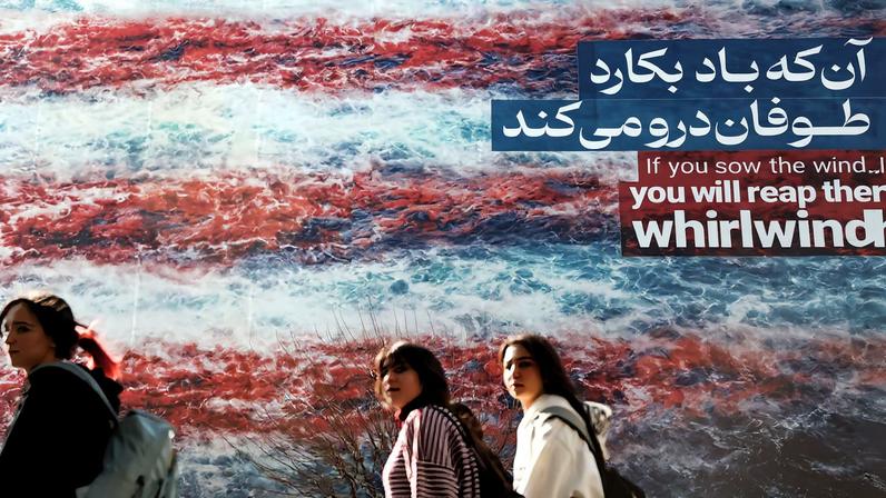 Iranian women walk past an anti-U.S. billboard in Tehran, Iran, February 19, 2026. Majid Asgaripour/WANA (West Asia News Agency) via REUTERS
