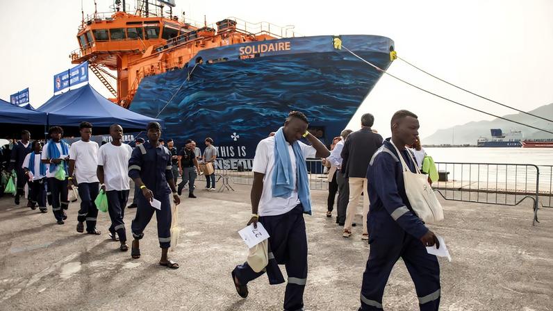 Unos hombres rescatados en el mar desembarcan en el puerto de Salerno, Italia, en una imagen de octubre de 2024.