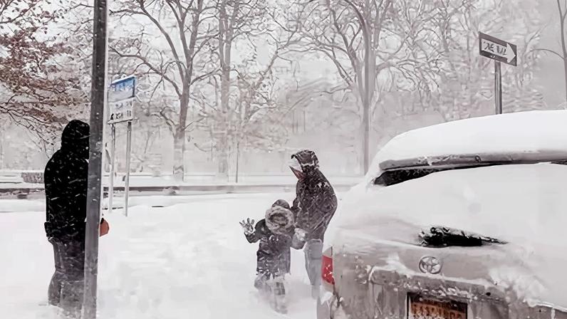 Varias personas caminan por la ciudad de Nueva York durante la tormenta de nieve este lunes.