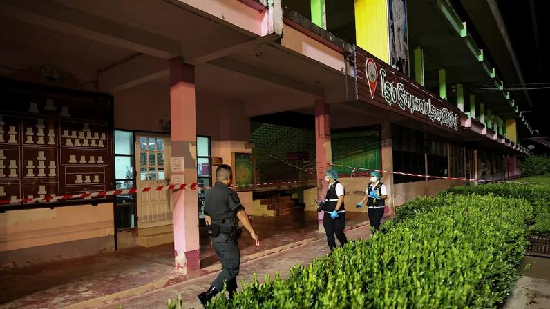 Members of the forensic team and a police officer walk near the building inside Patongprathankiriwat School, where a gunman held an unknown number of students and teachers hostage, in Songkhla province, Thailand, February 11, 2026.