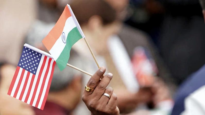An attendee holds U.S. and India's flags as they gather on the South Lawn of the White House in Washington