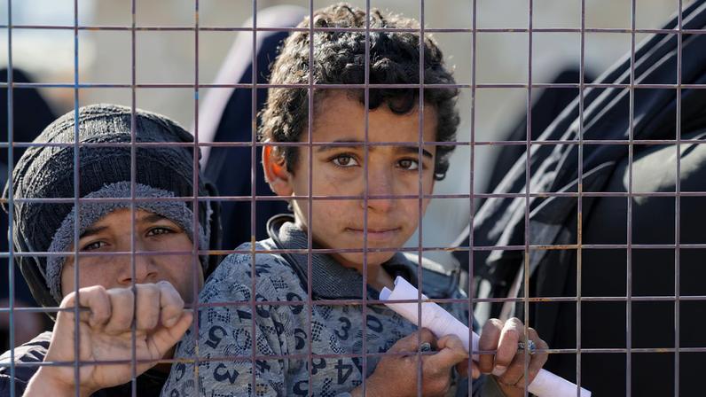 Children, part of a group of detainees, look through a fence at al-Hol camp after the Syrian government took control of it following the withdrawal of Syrian Democratic Forces (SDF), in Hasaka, Syria, January 21, 2026.