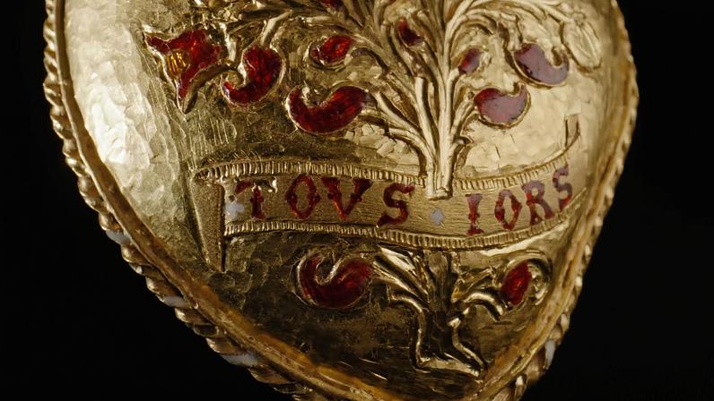 The pendant features the words Tous Iors—which may be a pun on the French word “toujours”, or “always”