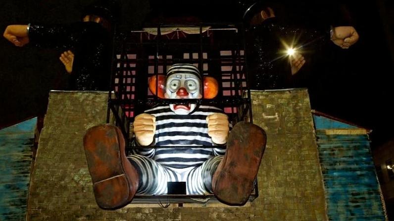 Carro alegórico do desfile da Acadêmicos de Niterói, em homenagem a Lula, mostra palhaço preso com tornozeleira eletrônica danificada.