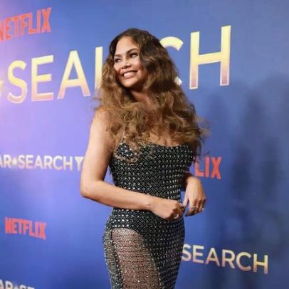 Chrissy Teigen desfila no Star Search com vestido transparente e brilhante
