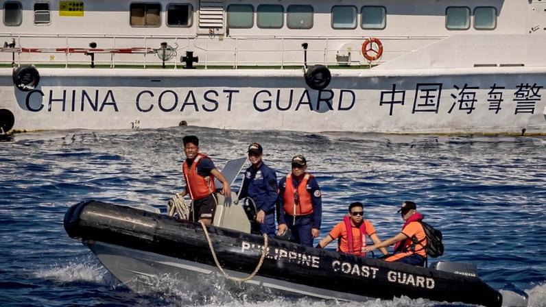 Philippine Coast Guard personnel sail past a Chinese Coast Guard vessel during a resupply mission to troops stationed at Second Thomas Shoal in the South China Sea on March 5, 2024.