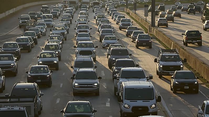 Reuters A freeway crowded with lines of cars, many with headlamps on, all bathed in the orange light of early morning in Los Angeles