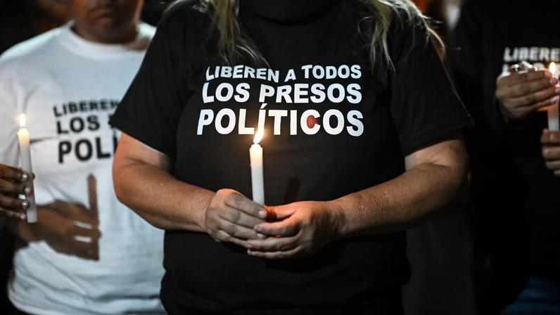A woman holds a candle during a vigil to demand the freedom of Venezuelan political prisoners.