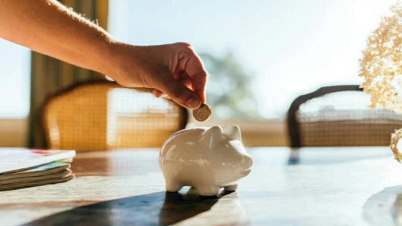 Ilustração de pessoa colocando moedas em um porquinho