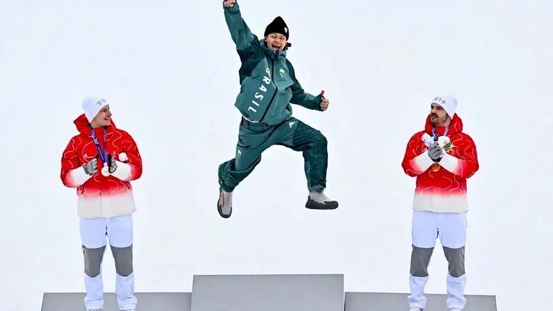 Da esquerda para a direita, Marco Odermatt (prata), Lucas Pinheiro Braathen (ouro) e Loic Meillard (bronze) celebram no pódio do slalom gigante masculino em 2026. (Foto: Fabrice Coffrini/AFP)