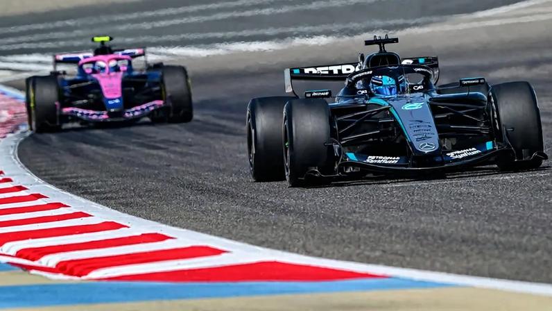 Mercedes' British driver George Russell drives ahead of Alpine's Argentine driver Franco Colapinto on the third day of the Formula One pre-season testing at the Bahrain International Circuit in Sakhir on February 13, 2026. (Photo by Giuseppe CACACE / AFP)