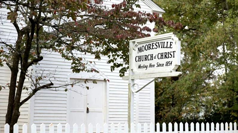 A sign in front of the historic Mooresville Church of Christ notes the meetinghouse’s founding date of 1854.