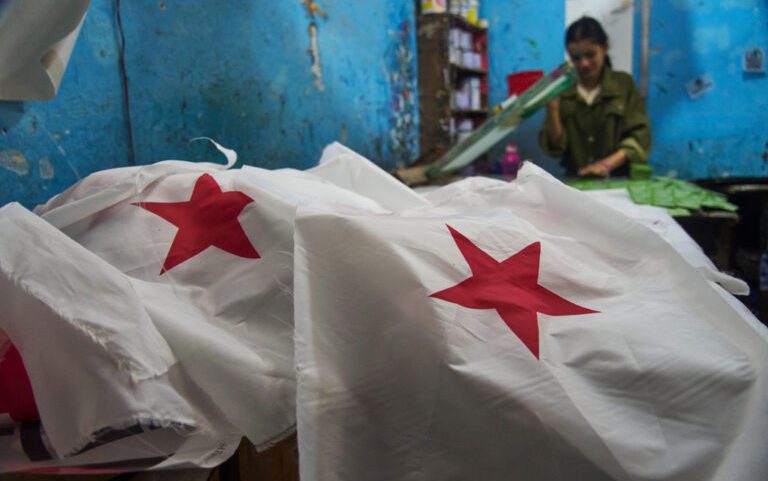 A worker screen-prints flags of the Nepali Congress Party for sale ahead of general election in Kathmandu, Jan. 27, 2026.