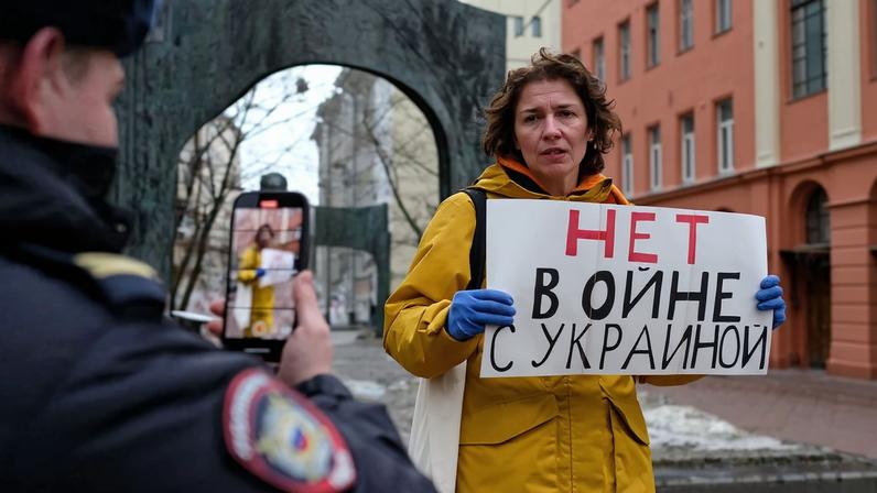 Russian woman with anti-war sign observed by police in Moscow