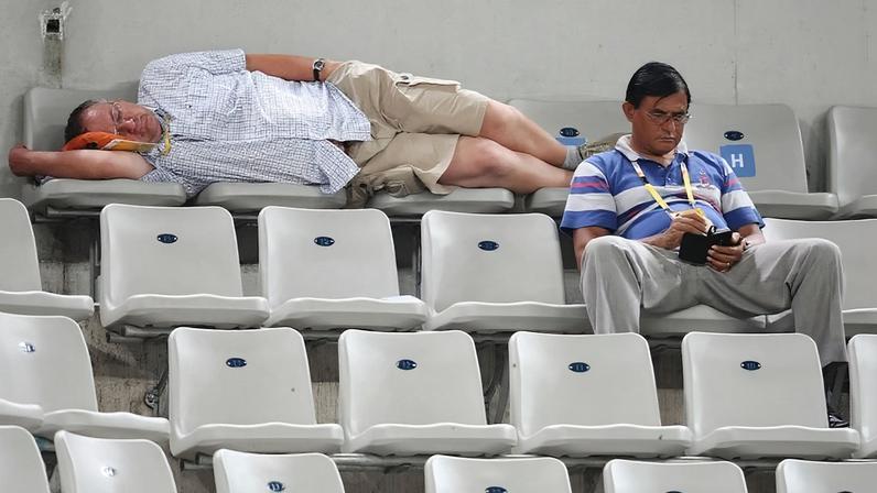 Members of the media sleep during a tennis match at the 2008 Beijing Olympics on Aug. 15, 2008.